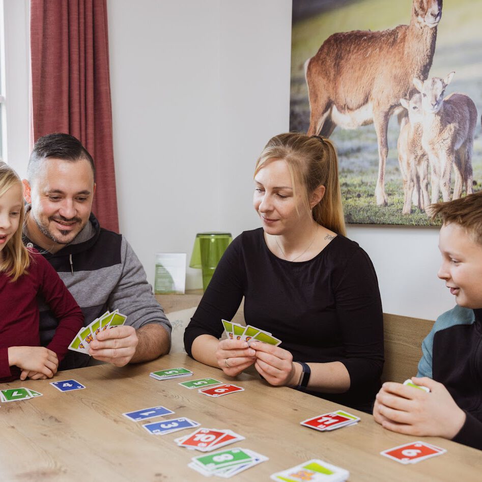 Familie spielt Karten im Komfort-Appartement